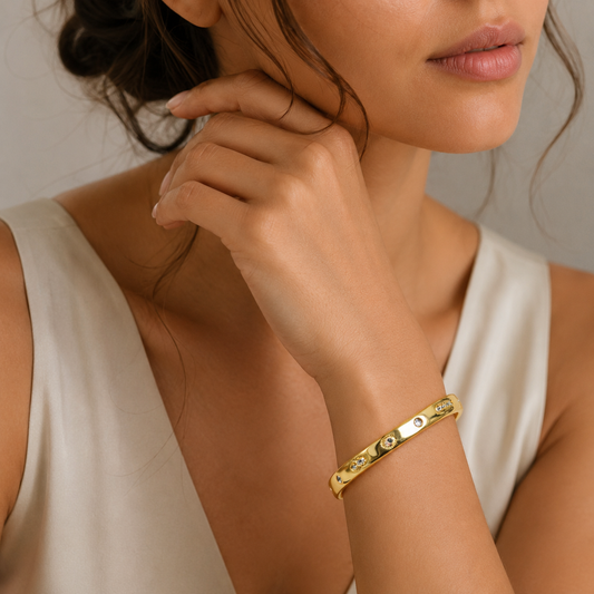 18K gold plated engraved open cuff bracelet worn on wrist.