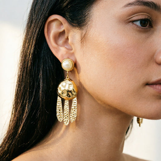 Close-up detail of 18K gold plated hammered tassel drop earrings showing textured gold finish and resin stud.