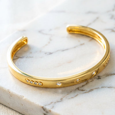 Close-up of engraved detail on 18K gold plated open cuff bracelet.